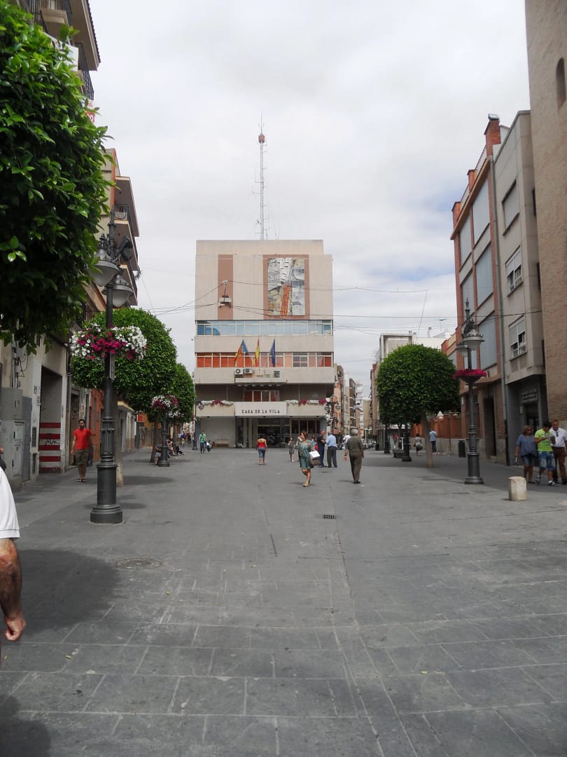 Vista urbana de Mislata con la Casa de la Vila al fondo, árboles podados y ambiente peatonal.